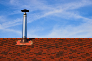 Metal chimney on the red roof
