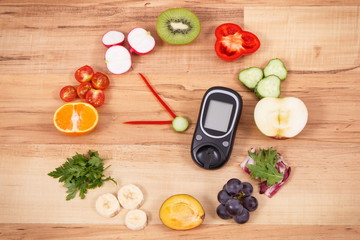 Glucometer for checking sugar level and fruits with vegetables in shape of clock, healthy breakfast for diabetics concept