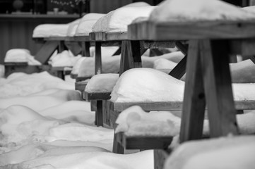 snow on benches black and white