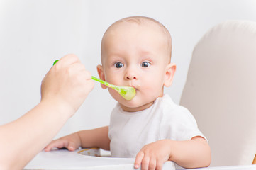 A little baby eats, feeding a small child