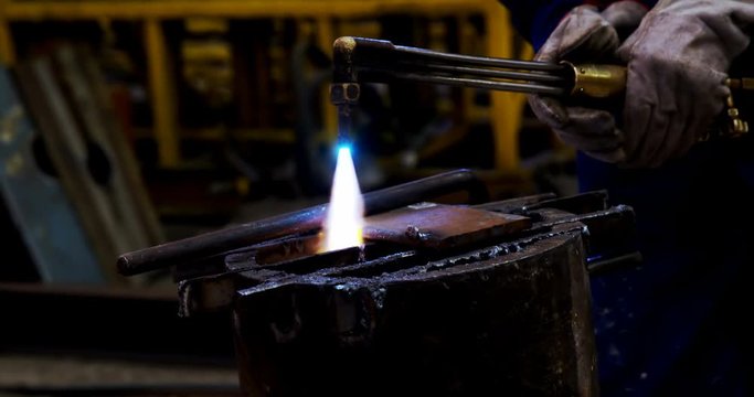 Male engineer using velding torch in workshop 4k