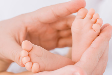 Obraz na płótnie Canvas Close-up of mother hands holding tiny baby feet