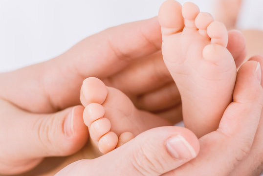 Close-up of mother hands holding tiny baby feet