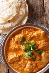 The chicken changezi of slow cooking complete with rich ingredients cream, cashew nuts, ghee, and the likes close-up on a plate. Vertical top view