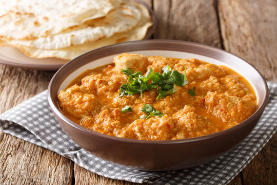 Delicious Indian chicken changezi in a spicy sauce served with flat bread close-up. horizontal