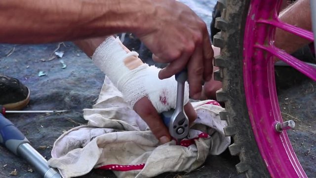 repairing a pink motorcycle with an already hurt hand