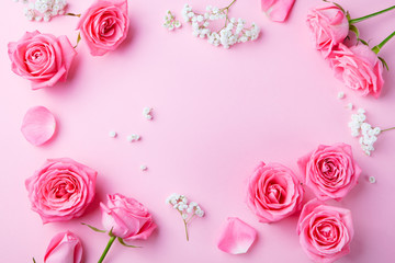 Fototapeta na wymiar Rose and gypsophila flowers frame on pink background. Top view. Copy space.