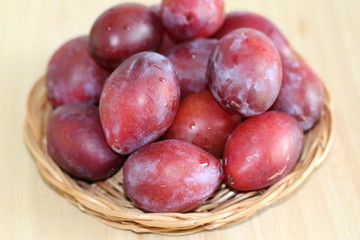 Fototapeta na wymiar Ripe plums on straw plate