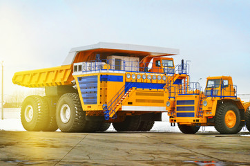 Mining dump truck at sunset on a concrete pavement. Yellow color equipment   © Varvara Shtern