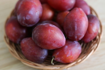 Ripe plums on straw plate
