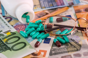 Colorful capsules with bottle on euro banknotes