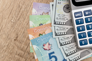 calculator with dollar usd and cad on desk