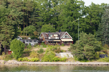 Fototapeta na wymiar Stockholm, Sweden, Beautiful houses in Stockholm fjord. Fjords is one of the attractions of the Scandinavian countries, long sea bays with beautiful nature, Islands, nice houses on the banks. 