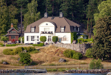 Fototapeta na wymiar Stockholm, Sweden, Beautiful houses in Stockholm fjord. Fjords is one of the attractions of the Scandinavian countries, long sea bays with beautiful nature, Islands, nice houses on the banks. 