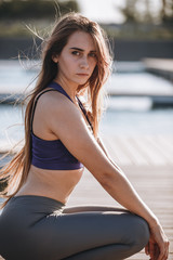 Young beautiful girl with long brown hair in a sports top and ti