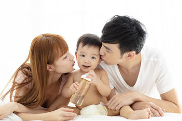 happy young father and mother  kissing  baby