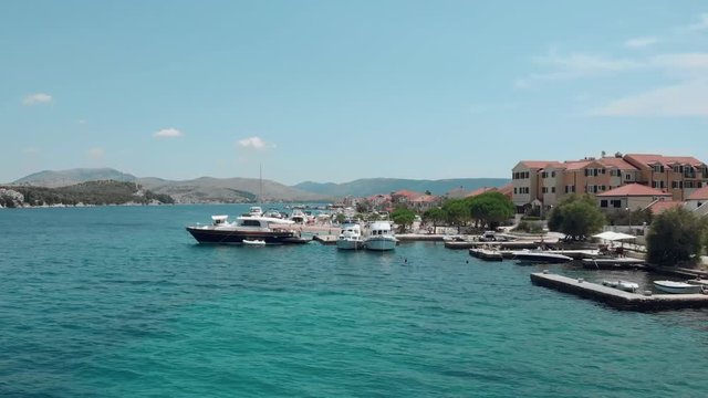 Beautiful aerial view of a small marina with boats and people swimming at the beach. Small cute island Krapanj. Croatia. Travel vacation destination. Holiday. 