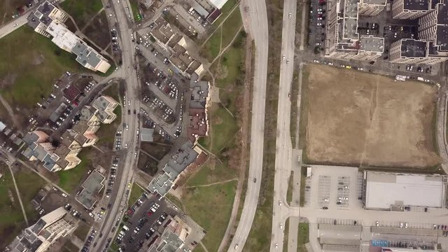 Flying over a concrete living apartment area in east Europa with many birds flying around the drone