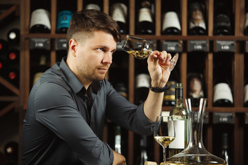 Sommelier looking at wine glass with beverage