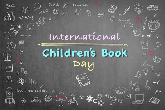 International Children's Book day greeting with doodle on grunge black chalkboard