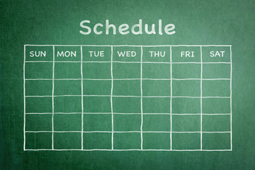 Schedule with grid timetable on green chalkboard