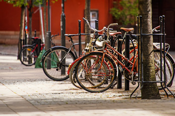 Fototapeta na wymiar Bicycles parked on bike parking on old cobblestone street of Stockholm, Sweden