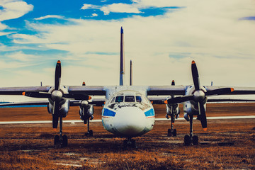 an old cargo propeller plane is standing in a parking lot near the runway, toned background image