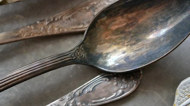 panoramic close up shot of silverware silver spoons on a vintage retro tray