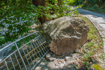 Obraz premium huge stone that fell from the mountain and damaged the fence