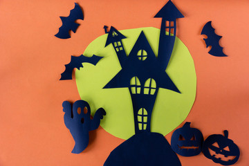 Halloween concept with haunted house castle and black cat and moon and pumpkin on orange background.