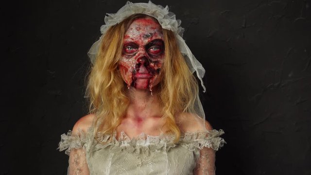 Incredible professional Halloween zombie makeup on young blonde face creepy spooky dead bride wife dirty wedding dress
