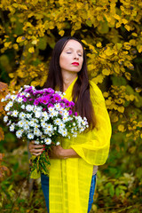 Beautiful woman with a bouquet in the autumn Park