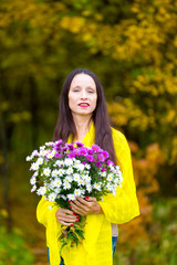 Beautiful woman with a bouquet in the autumn Park