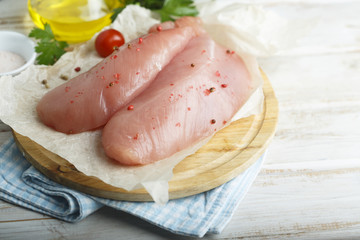Chicken fillet, uncooked on the rustic desk with other ingredients