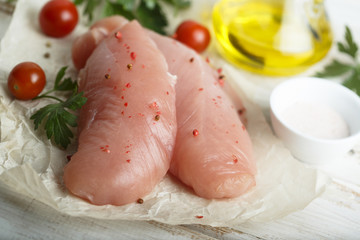 Chicken fillet, uncooked on the rustic desk with other ingredients