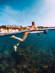 Beautiful surfer woman relax with surfboard. Surfgirl in ocean.