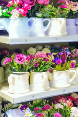 Artificial potted flowers on shelves in a store