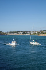 Obraz premium Petit bateau de pêche et bateau de plaisance se croisant dans la baie d'Audierne (Finistère)