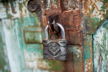 Old metallic padlock on wood, I have not painted the gate. Green shabby paint.