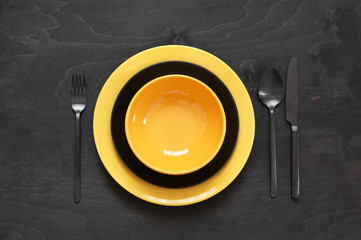 Yellow tableware on black wood