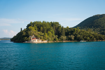 Blue ocean landscape with green hills and houses