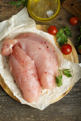 Chicken fillet, uncooked on the rustic desk with other ingredients