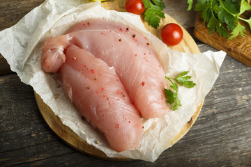 Chicken fillet, uncooked on the rustic desk with other ingredients