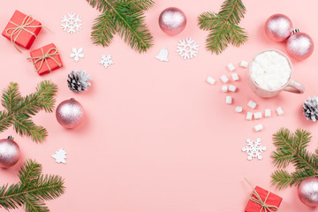 Christmas background with fir branches, lights, red giftboxes, pink decorations, hot drink with marshmallows on pink