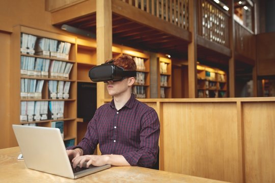 College student using laptop and virtual reality headset