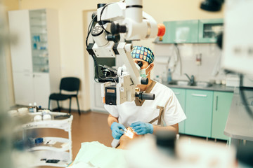 Fototapeta na wymiar Dentist examine oral cavity of female patient with microscope.