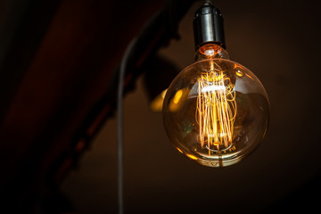 Close-up burning light bulb in loft style. retro glowing lamp on a black background