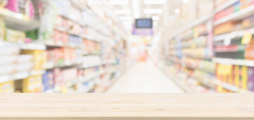 Wood table top with supermarket aisle blur background for product display