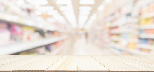 Wood table top with supermarket aisle blur background for product display