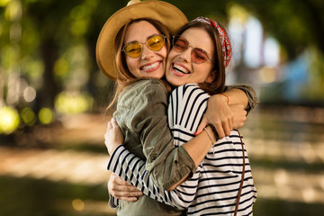 Pretty young happy women friends walking outdoors